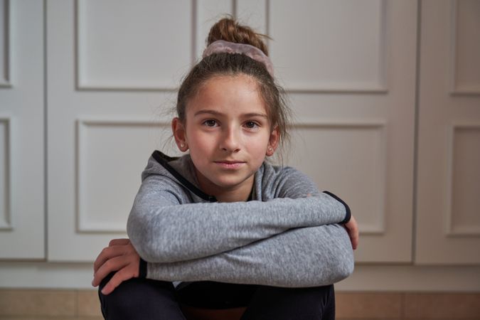 Portrait of gymnastic girl sitting at home