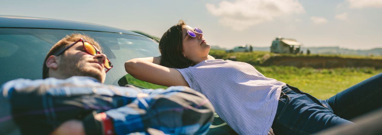 Young couple lying on the windshield