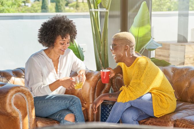 Cheerful diverse women having fun on sofa at home