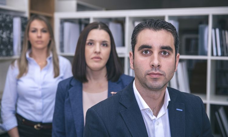Businessman looking at camera with colleagues in background