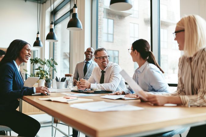 Group of business people smiling and working together in a bright office