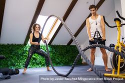 Couple doing rope exercise in home gym 0LdNVA