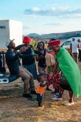 Group of people in traditional Zulu clothes talking and laughing outside