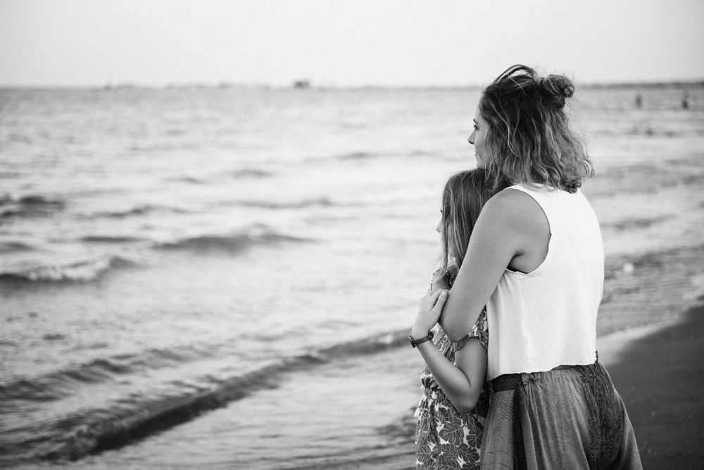 Beautiful mother and daughter embracing on beach