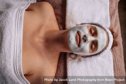 Woman with facial mask lying on spa table 5wXq9R