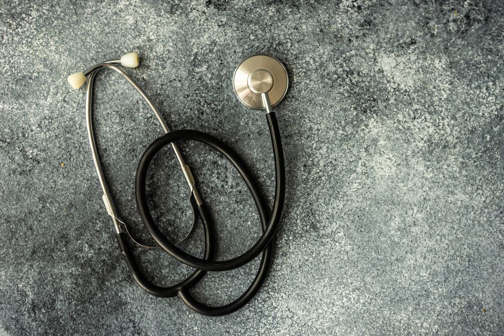 Top view of stethoscope on grey counter with copy space