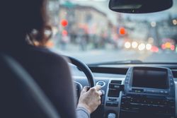 Woman driving car on city street