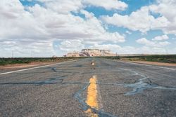 Asphalt road at scenic mountain valley and power line