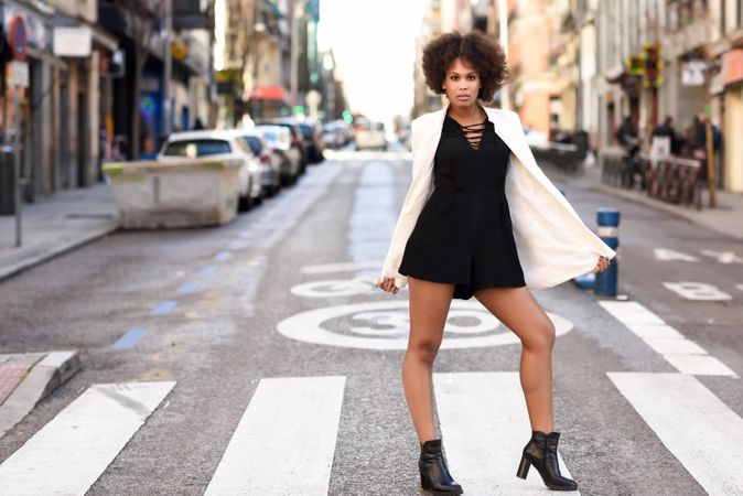 Female in short dress, heels and blazer standing on street