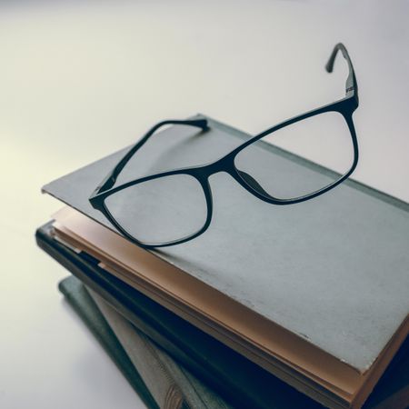 Framed eyeglasses on stack of books