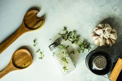 Salt and pepper shakers, thyme and garlic on marble counter with copy space