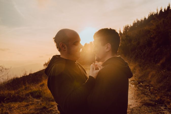 Men hugging and kissing in forest
