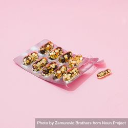 Pill packer with glitter in place of pills on pink background bGWoab