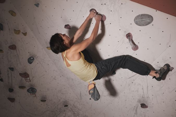 Young woman climbing on wall