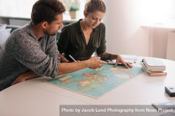 Man and woman planning trip with world map 5zrwqP