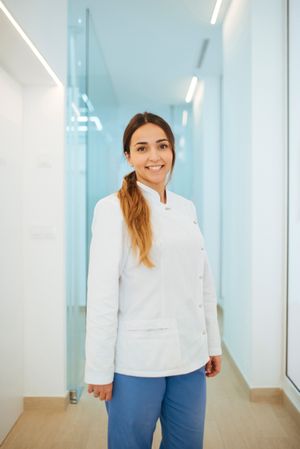 Confident dentist in uniform with crossed arms looking at camera