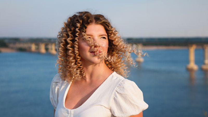 Portrait curly haired woman at the coast