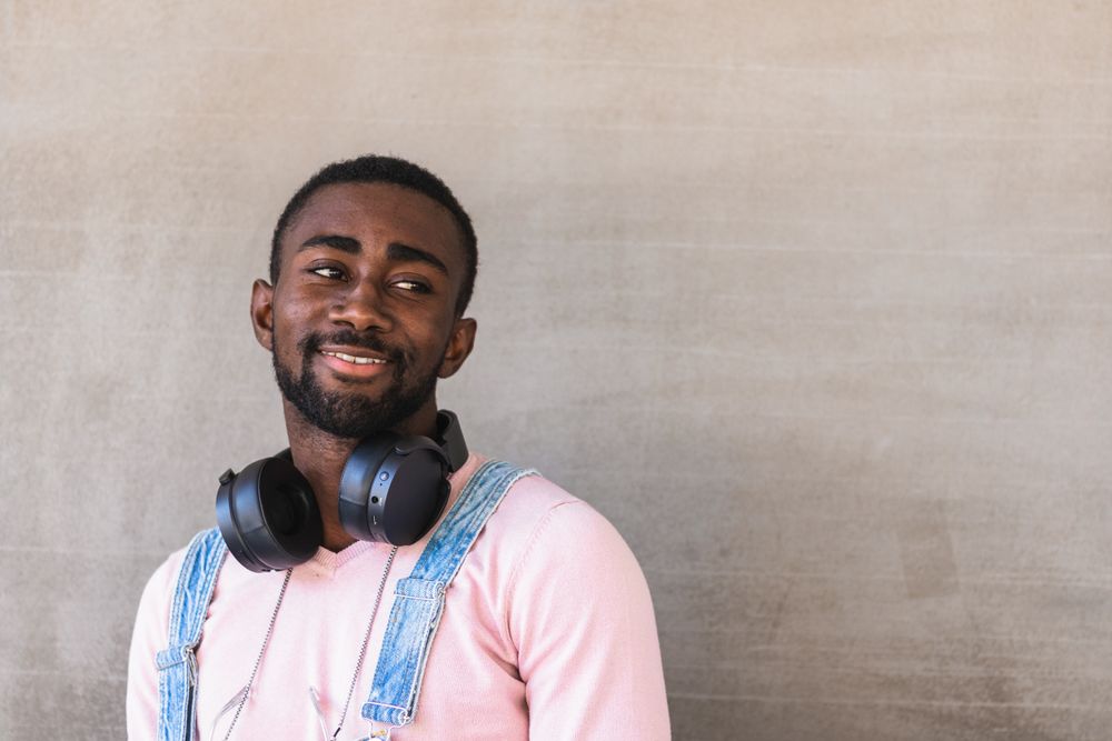 Smiling Black man with headphones on street