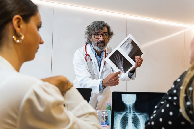 Doctor discussing x ray with colleagues in hospital