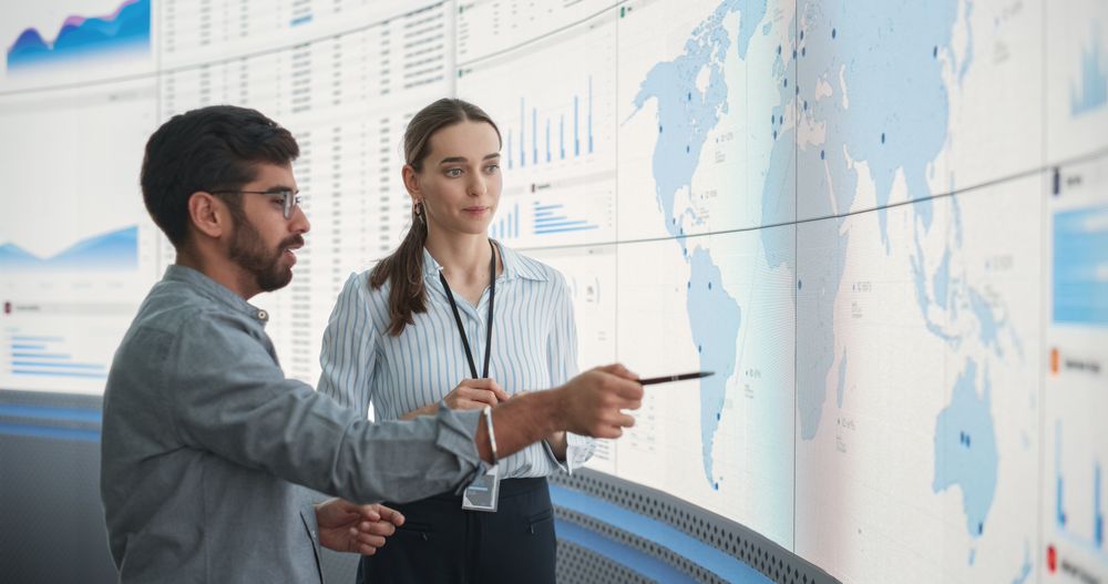 Successful Man And Woman Discussing New Markets For Expansion.