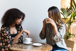 Multiethnic girlfriends with coffee spending time in cafe