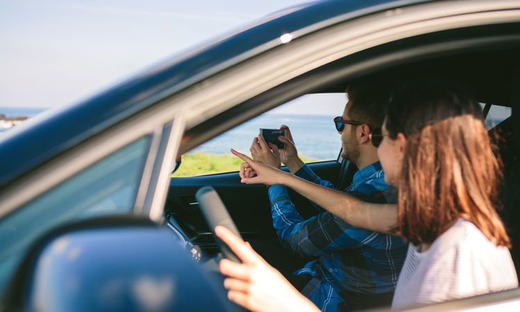 Couple taking picture of landscape from the car