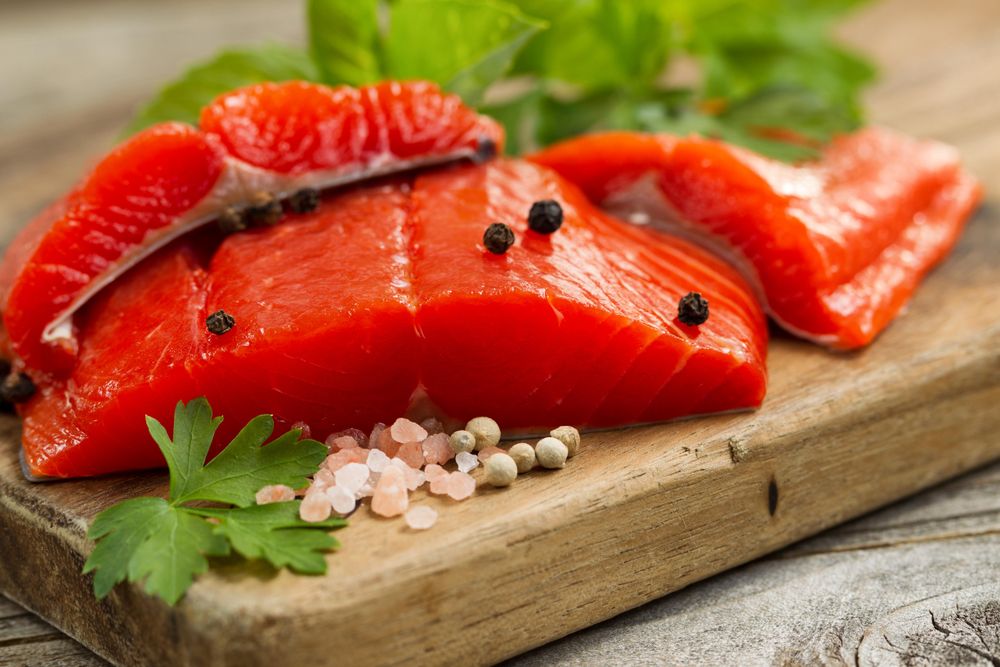 Fresh Copper River salmon fillets on rustic wooden server