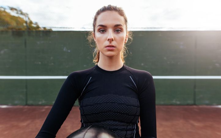 Portrait of sporty young woman on tennis court