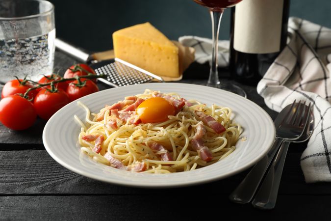 Composition with plate of tasty pasta and wine on wooden background