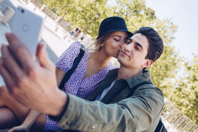 Happy young couple taking selfie in park