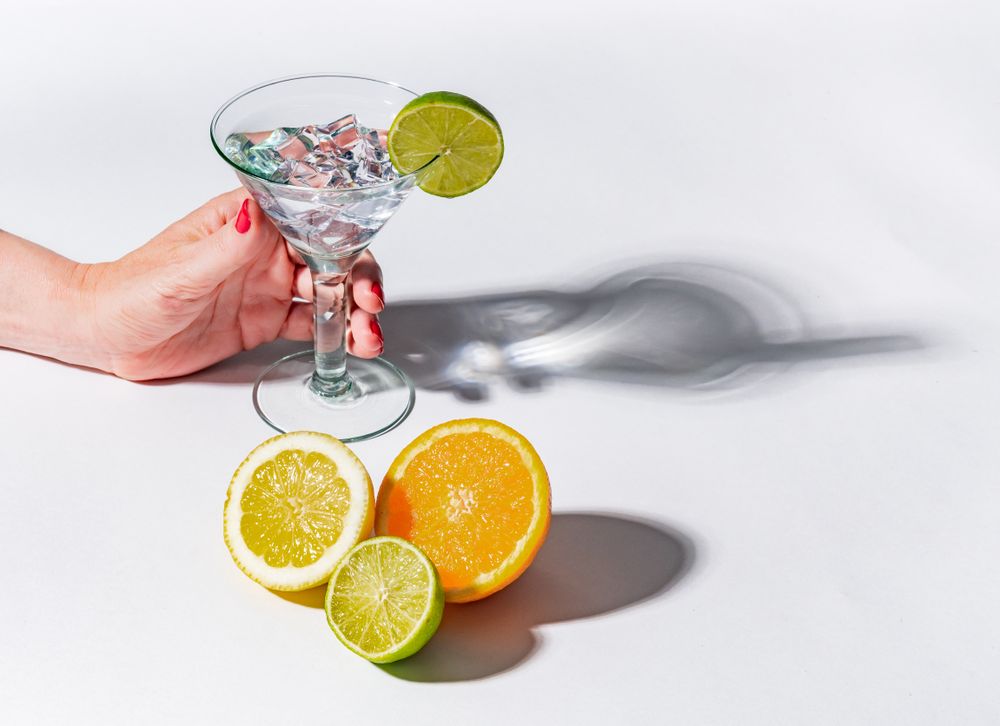 Cocktail glass with ice cubes and sliced citrus