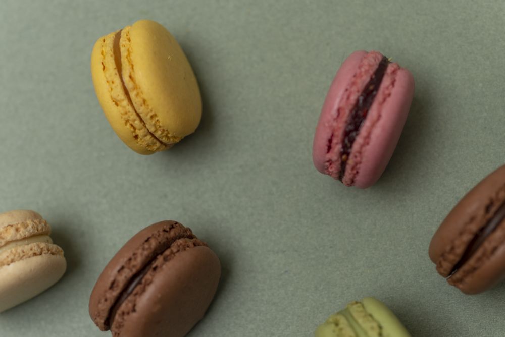 Cake macaroons on green background from above