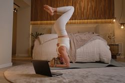 Strong woman doing yoga in bedroom