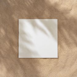 Sand with palm leaf shadows and central square