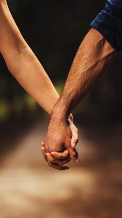 Close up of loving couple holding hands in the park