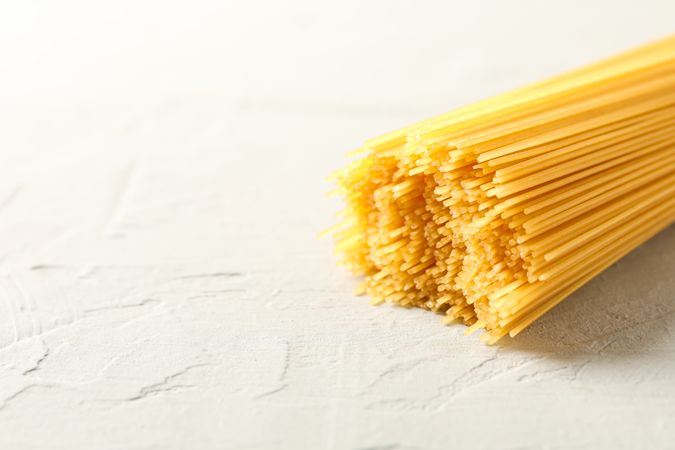 Pasta on light background, space for text and closeup. Uncooked whole wheat pasta
