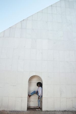 Man with Afro hair posing beside light door