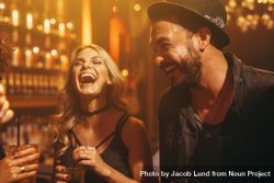 Man and woman laughing with friends in nightclub bERNN0