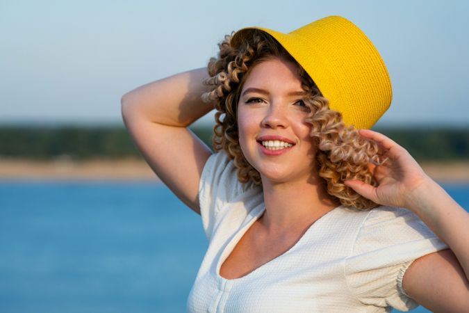 Portrait smiling woman in yellow hat in windy outdoors