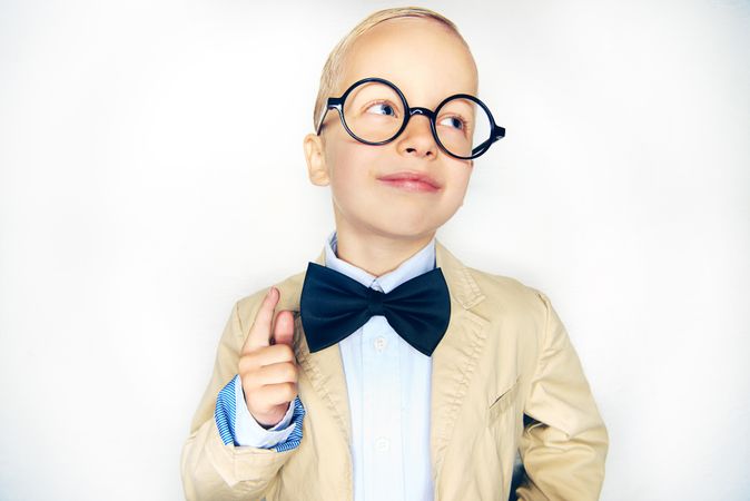 Curious blond boy in glasses and bow tie