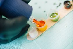 Close up of tattoo gun being loaded up with orange ink