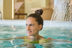 Happy woman swimming in spa pool