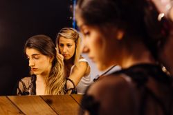 Female actress making hairstyle by illuminated mirror