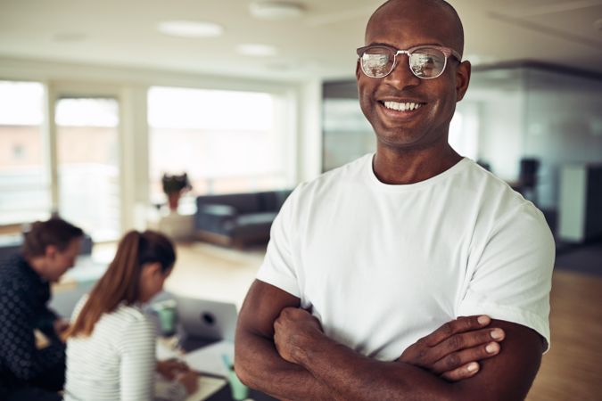 Portrait of happy Black businessman with his arms crossed