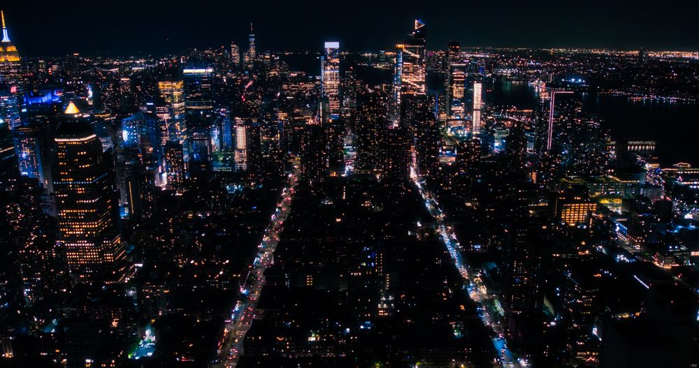 Aerial Helicopter View of Downtown Manhattan Architecture. Drone Photo of Skyscrapers and Office Buildings at Night. Evening Urban Landscape with Historic New York City