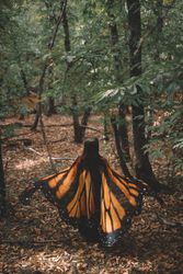 Woman in butterfly costume in forest