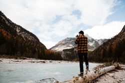 Man delighting in views near lake and mountains