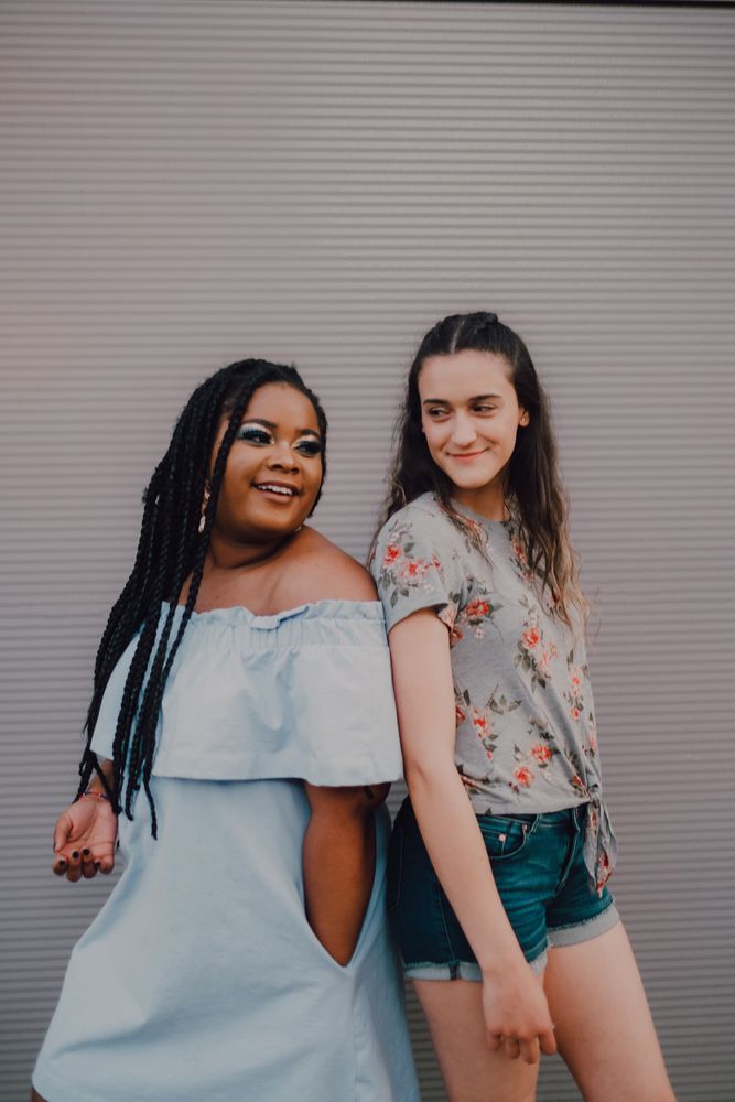 Multiethnic modern women embracing on street wall