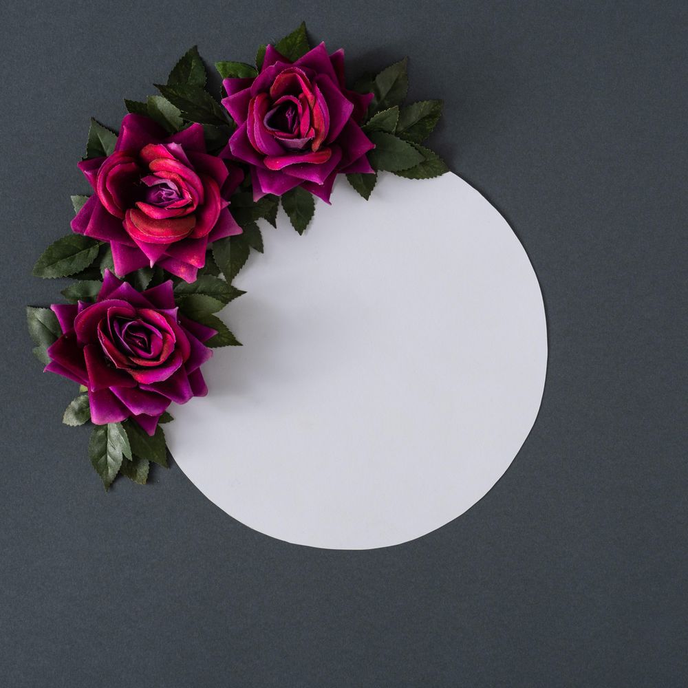 Purple flowers and leaves on gray background with paper card