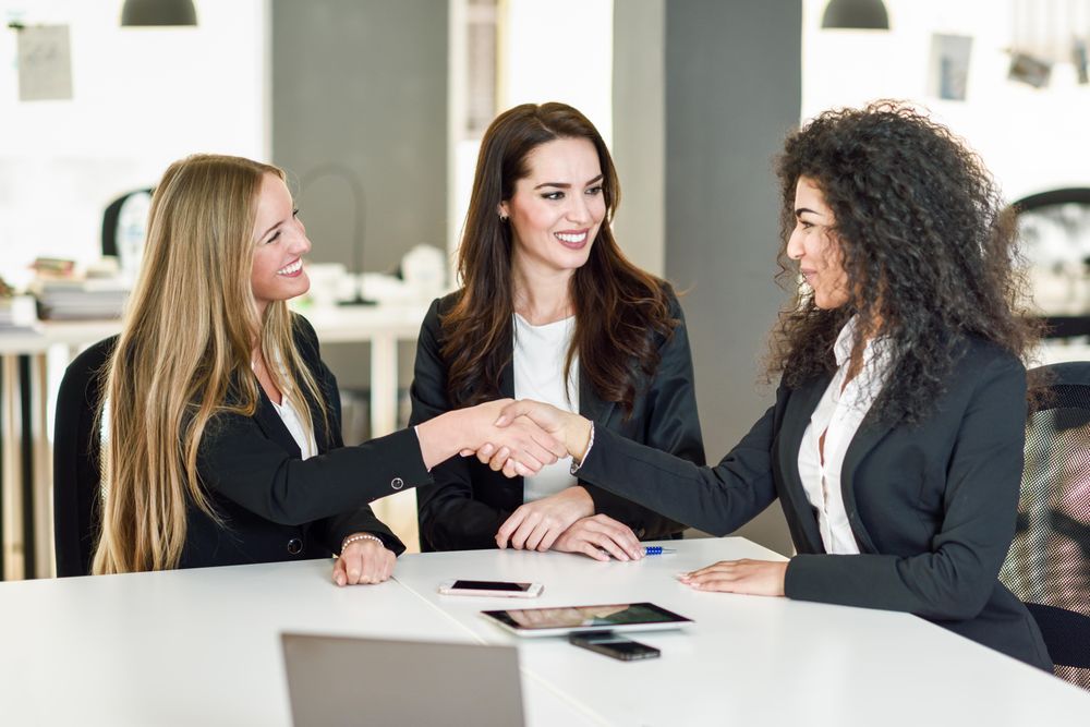 Women business leaders shaking hands in office after a successful meeting